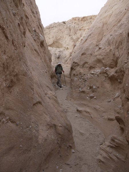 A hiker enters Canyon Sin Nombre 760 Slot Canyon from the top.