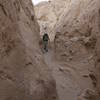 A hiker enters Canyon Sin Nombre 760 Slot Canyon from the top.