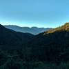 A new day dawns over the landscape on the porch of the Perry Saddle Hut on the Heaphy Track.