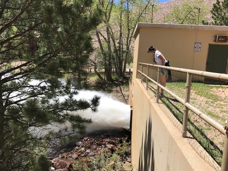 A hiker inspects the dam outlet into North St. Vrain Creek.