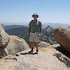 A hiker poses atop Gaskill Peak with Lawson Peak in the center-right.