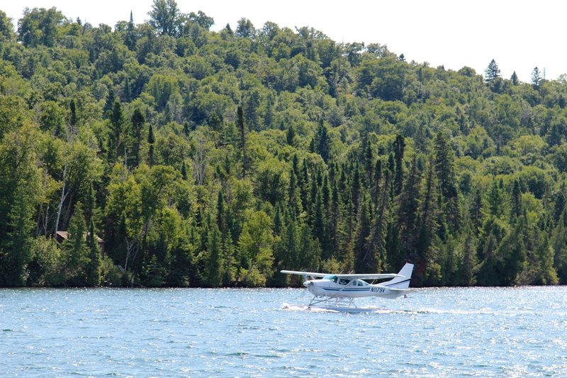 A seaplane daintily lands on the water near Windigo.