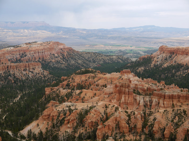 Peekaboo Loop trail in the foreground and the city of Tropic in the distance seen from the Rim Trail in Bryce Canyon National Park.