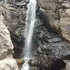 Rocky Mouth Waterfall cascades into a rocky alcove.