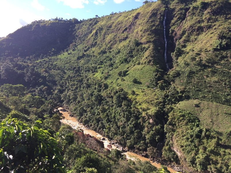 A tall waterfall cascades into the Magdalena River.