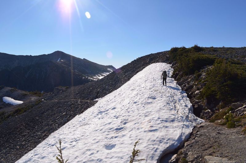 A hiker makes their way around Skyscraper Pass.