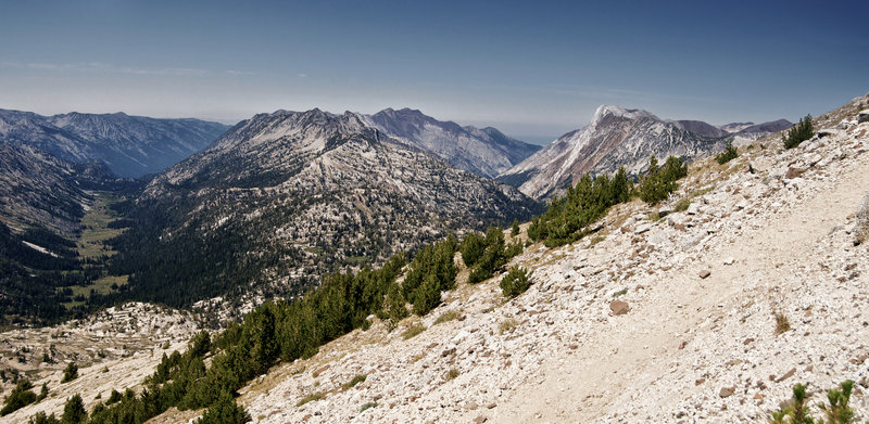 The loose and gravelly trail at the top climbs through dwarfed trees and distant views.