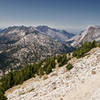 The loose and gravelly trail at the top climbs through dwarfed trees and distant views.