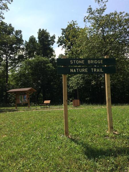 The Trailhead and signage for Stone Bridge Nature Trail as seen from the road. (Tireman Ave.)