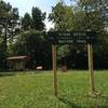 The Trailhead and signage for Stone Bridge Nature Trail as seen from the road. (Tireman Ave.)