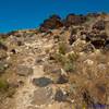 Trail runs through lava boulders near the mesa top