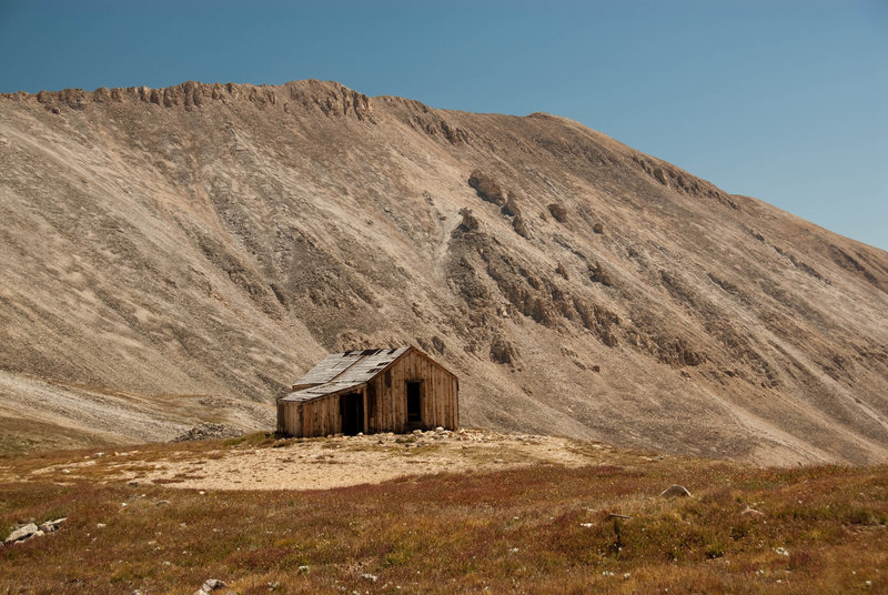 An old mining cabin with an impressive backdrop.