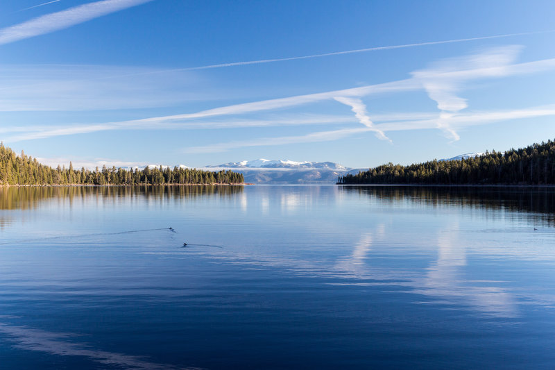 View across Emerald Bay from Rubicon Trail with the snow covered mountains on the other side of Lake Tahoe in the background