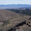 On Rendija Ridge looking east down the ridgeline trail. Santa Fe Baldy in the Sangre de Cristo Mountains north of Santa Fe is in the center of the background. Los Alamos townsite is in the right foreground.