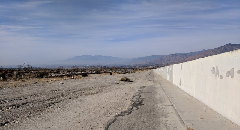 Photo shows the wall blocking scenery as well as the condition of the paving