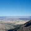 The moon rises above Arizona from the trail in the late afternoon.  You can see the 16 foot border wall stretching into the distance from the peak.