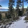 View of the lake with a few inches of snow on the trail