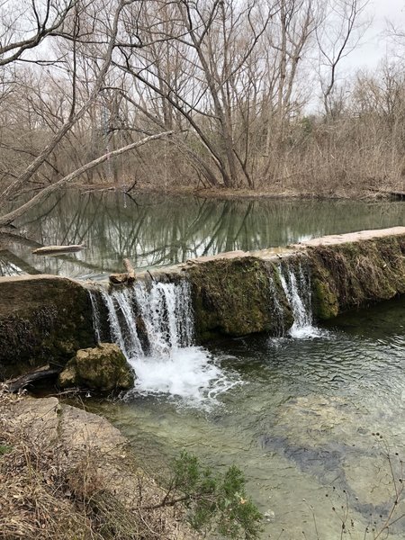 Waterfall and rope swing at trail loop base.