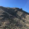 A Mountain with radio towers sits above the trail