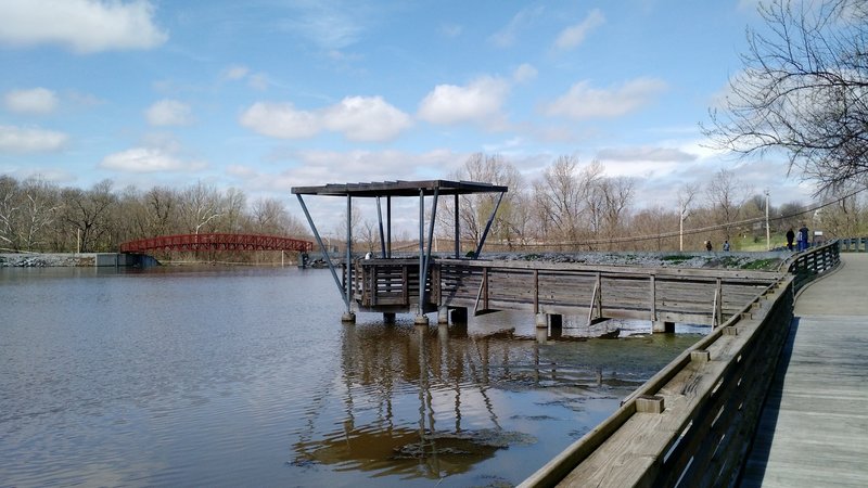 One of the two fishing piers on the flat side of the lake with the bridge over the spillway in the background.