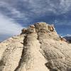 From the lower peak, facing the "pimple" dome".  Once on top, you'll find other adventurers have been thoughtful enough to scratch their names into the sandstone - don't be that type of idiot.