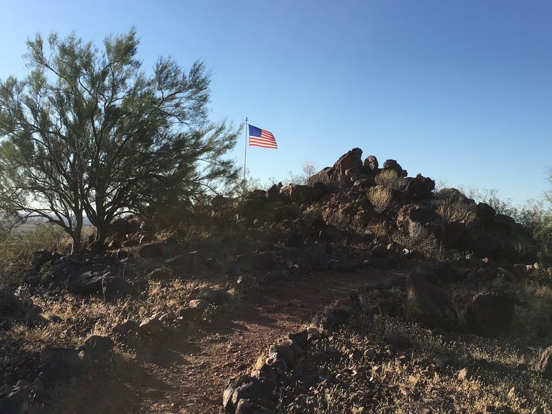 The trail continues past the flag to make its way to the summit.