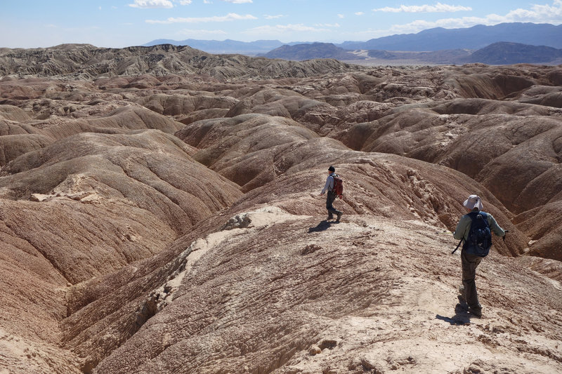 Two hikers descend into the badlands near Font's Point.