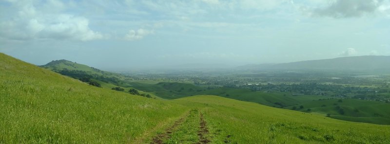 Rural southern Santa Clara Valley stretches as far as the eye can see, to the south, as seen from Coyote Ridge Trail. The Santa Cruz Mountains rise in the distance on the right.