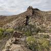 Atop the dike formation. Brush around the dike discourages scaling it but getting to the top is not difficult.