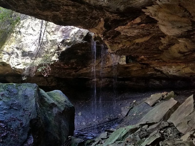 Large rock house with a little waterfall.