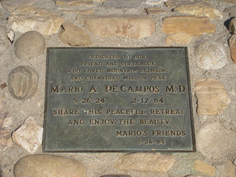 Monument at the top: "Dedicated to our / friend and colleague / who loved mountain climbing / and cherished Mission Peak / MARIO A DE CAMPOS MD / 5-26-24   2-17-84 / Share this peaceful retreat / and enjoy the beauty / Mario's friends / 5-26-84