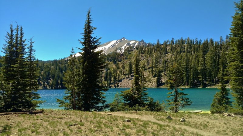 Lassen Peak is seen to the west, across Shadow Lake, as Terrace, Shadow, and Cliff Lakes Trail runs along the shoreline.