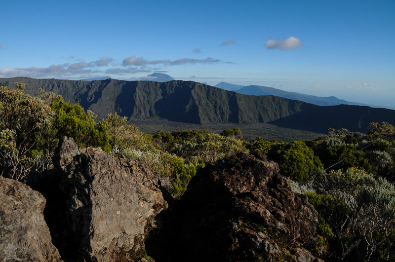 Piton des Neiges towers over the ravine carved by Riviere de l'Est. Parts of the heavily eroded shield of Piton des Neiges that surround Cirque de Salazie tower to the right.