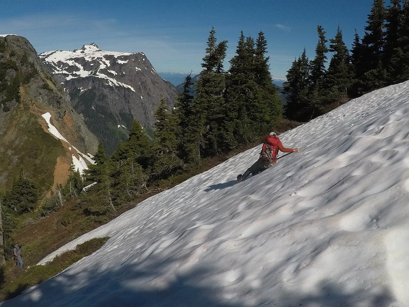 One hiker sliding down a snowbank.