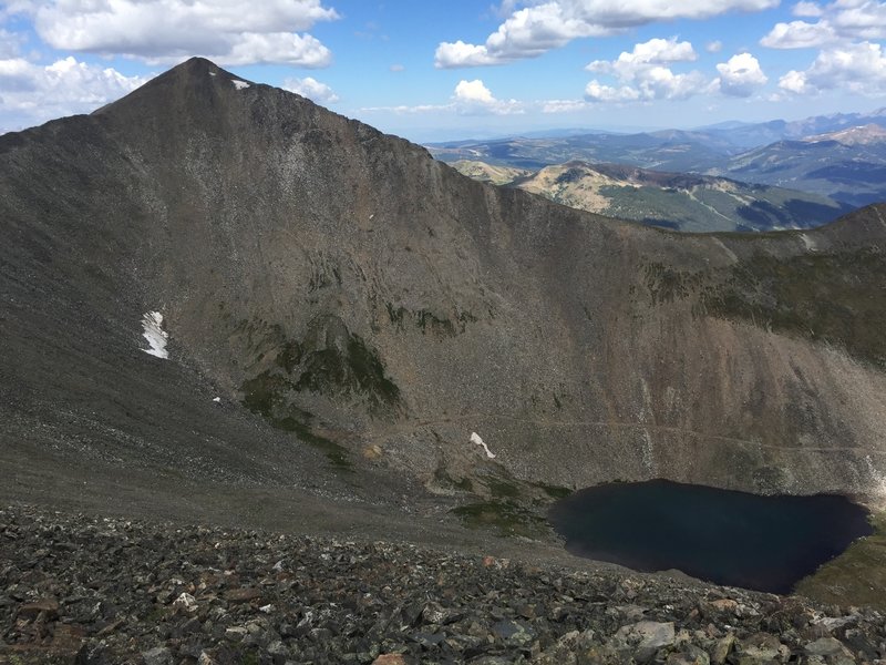 Looking at Crystal Peak from the ridge line of Father Dyer.  The Descent heads down the ridge to the right to the saddle and down steep grassy ledges to the trail you can see just above the upper Crystal lake