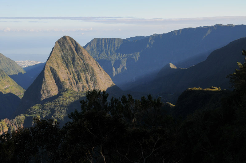 Early morning sun beams stream down from Roche Ecrite into Cirque de Mafate.