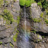 A small waterfall plunges towards Bras Bemale while creating a small rainbow