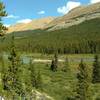 The Brazeau River runs through wet meadows dotted with firs, below an unnamed ridge, along the South Boundary Trail.