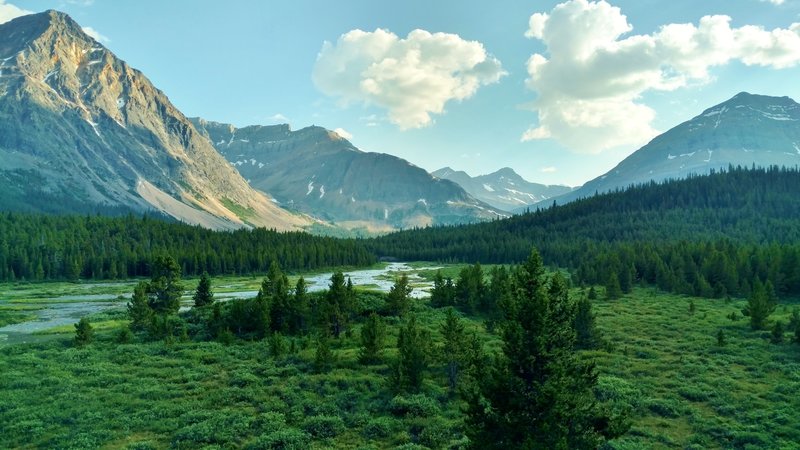 The Brazeau River meanders through the meadows in the shadows, as the mountains catch the last rays of the setting evening sun