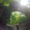 A hiker basking in the sunlight and the size of the arch.