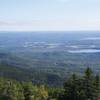 You can see the farmland below as the fields stand out against the evergreens.