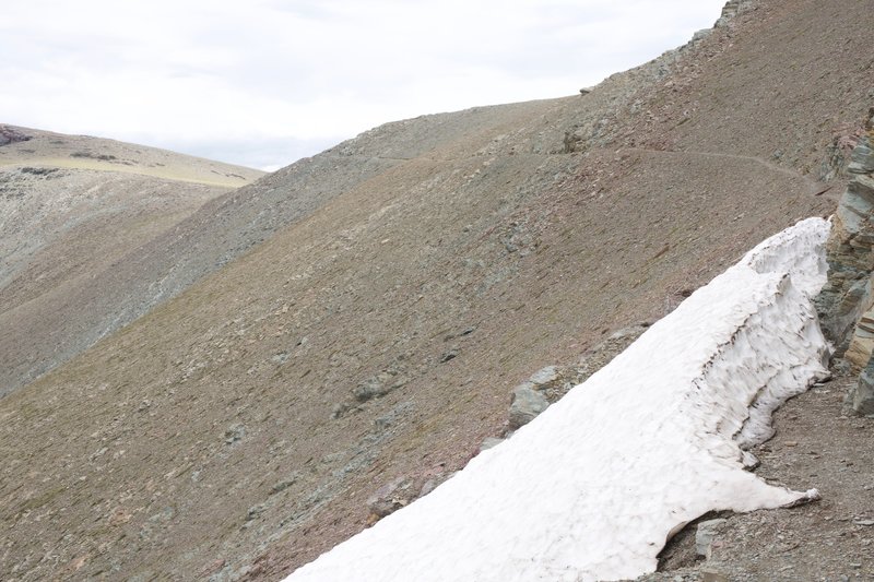 The trail might have snow lingering in shaded areas, even in late June. You can see the trail as it leads out to Scenic Point off in the distance.