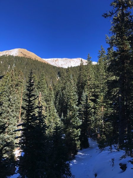 Steeper section of trail covered in snow on a nice afternoon.