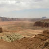 The tip of Temple of the Moon rising from the floor of Lower Cathedral Valley with Black Mountain and Factory Butte in the background.