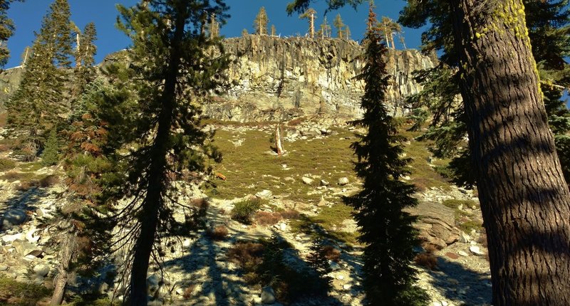 Looking up at an impressive rocky cliff with a rock slide at its base along Twin Meadows Trail.