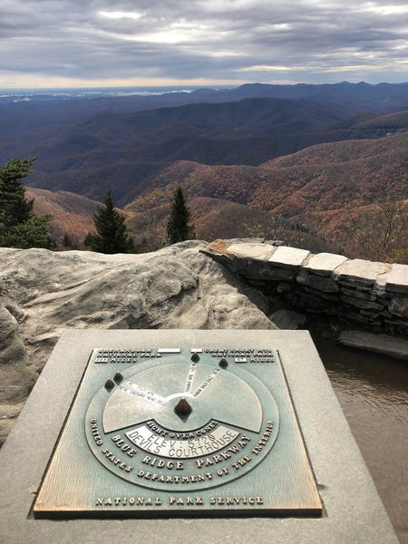 Summit plaque with directions of mountains in the distance.