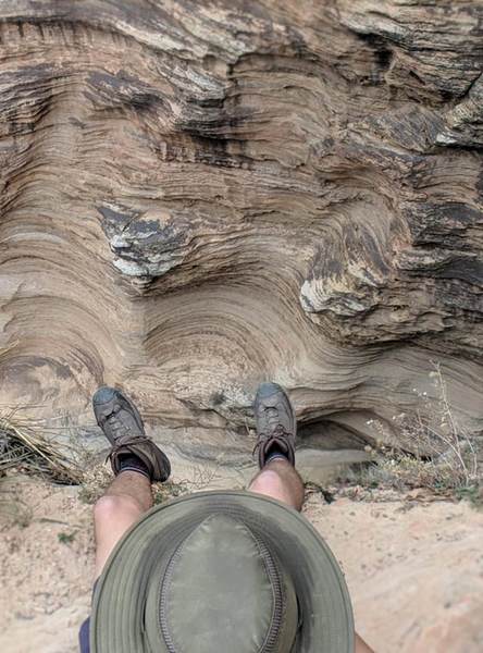 A hiker dangles his legs over the edge of Echo Canyon.