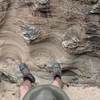 A hiker dangles his legs over the edge of Echo Canyon.