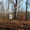 A small cemetery dedicated to the Hays on Grubb Ridge Trail. Grave markers are near the thicker trees behind the sign.