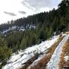 The trail carves across the mountain on a bright winter day.